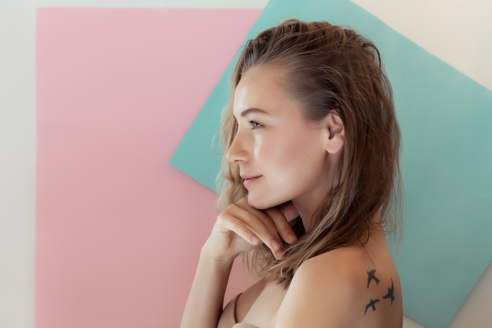 A woman with 3 birds tattooed on her shoulder.