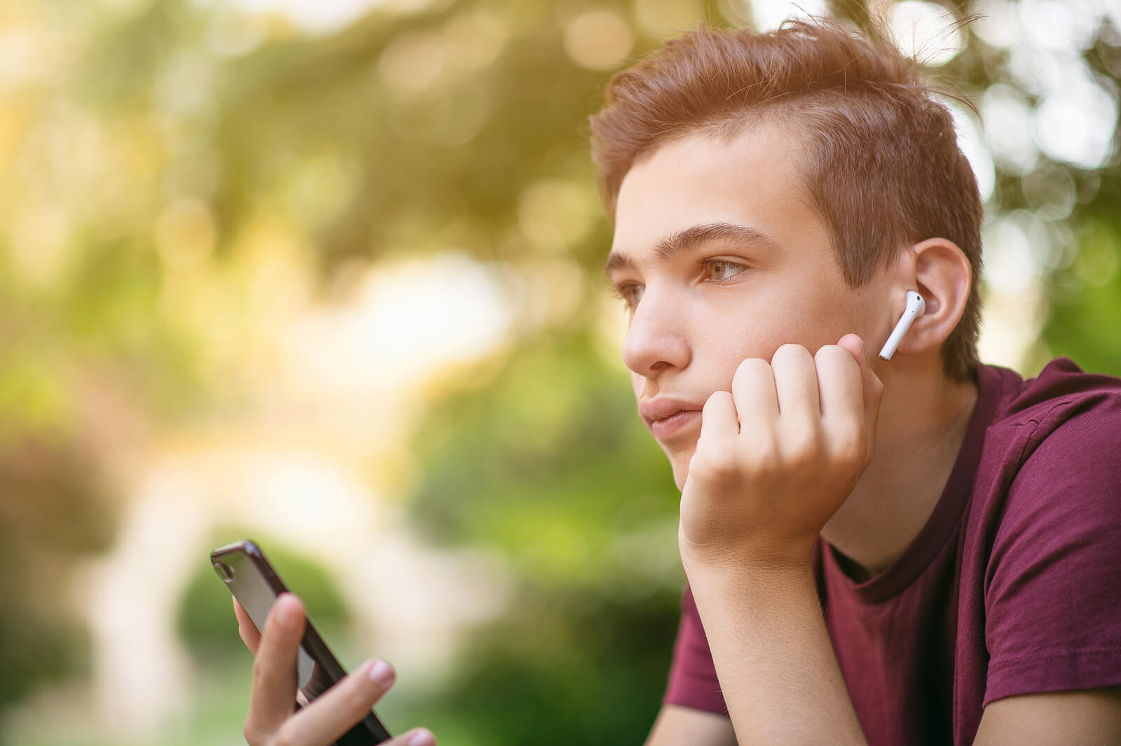 Chico adolescente enganchado al móvil, una de las adicciones sin sustancia más comunes.