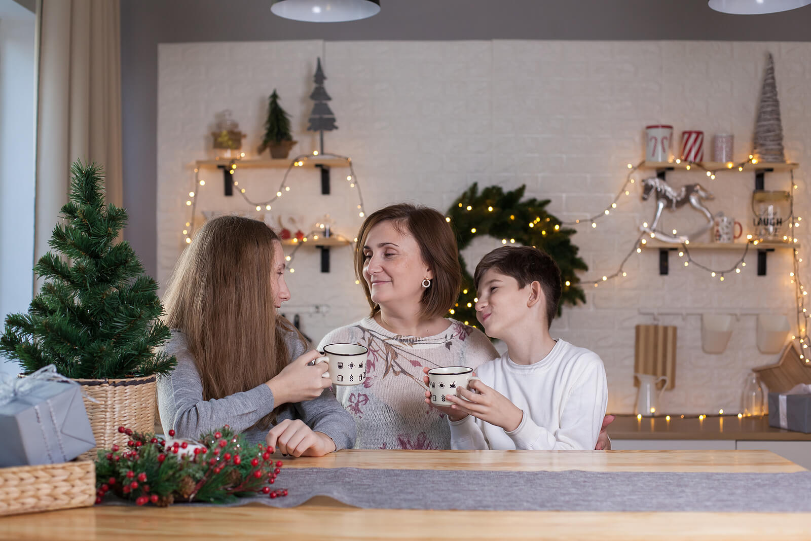 Madre con sus hijos tomando chocolate en Navidad.