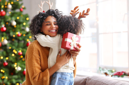 Hija dándole un regalo y un abrazo a su madre por Navidad.