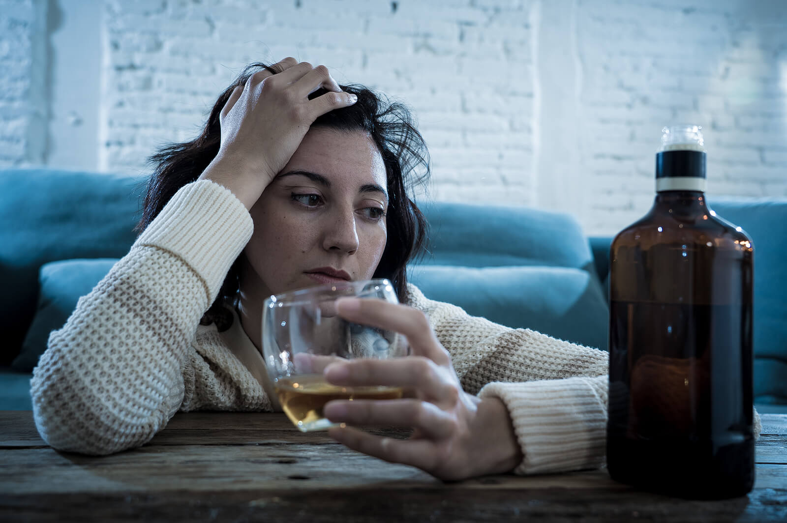 Mujer bebiendo alcohol sin parar; sufre alcoholismo materno.