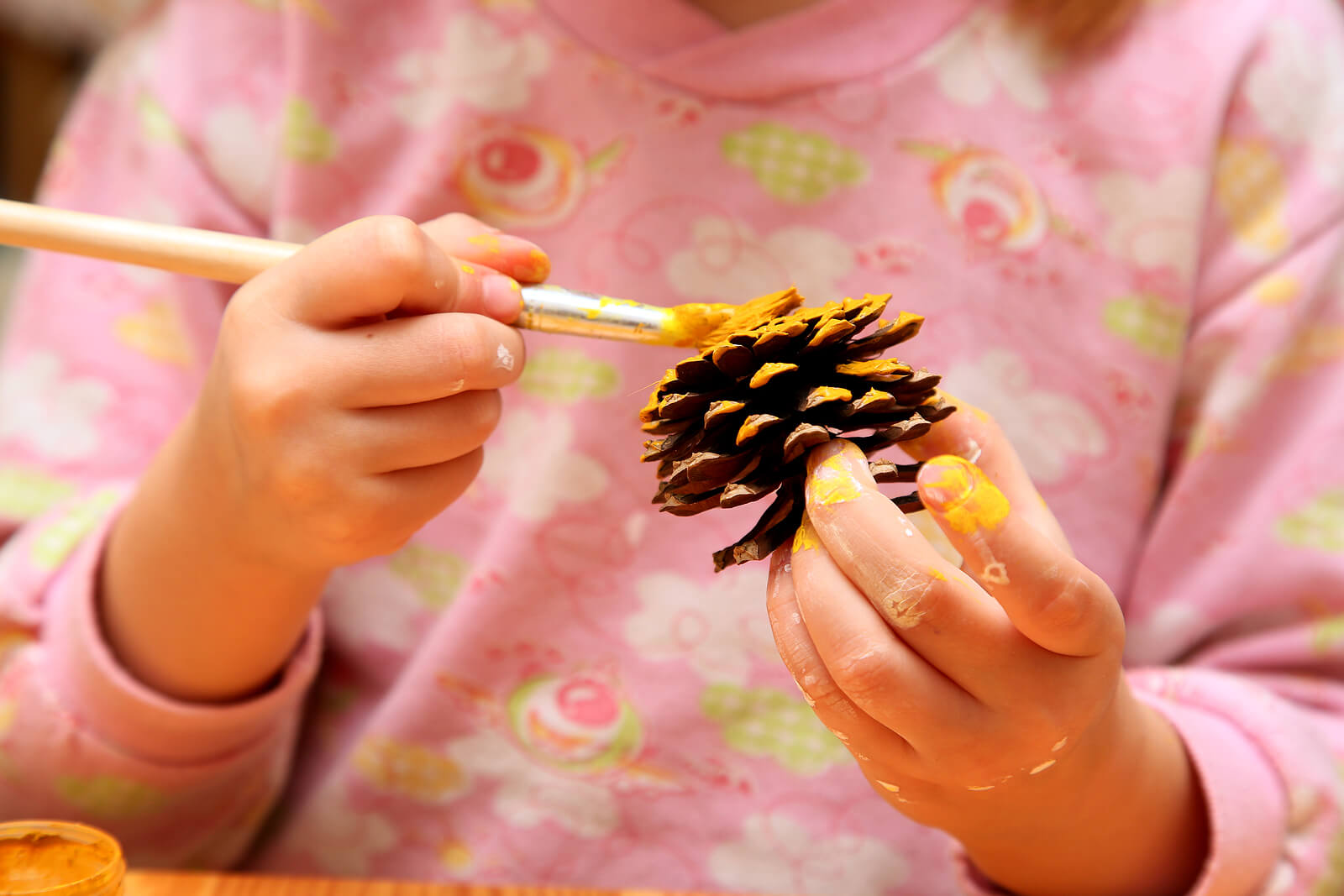 Peinture sur une pomme de pin.