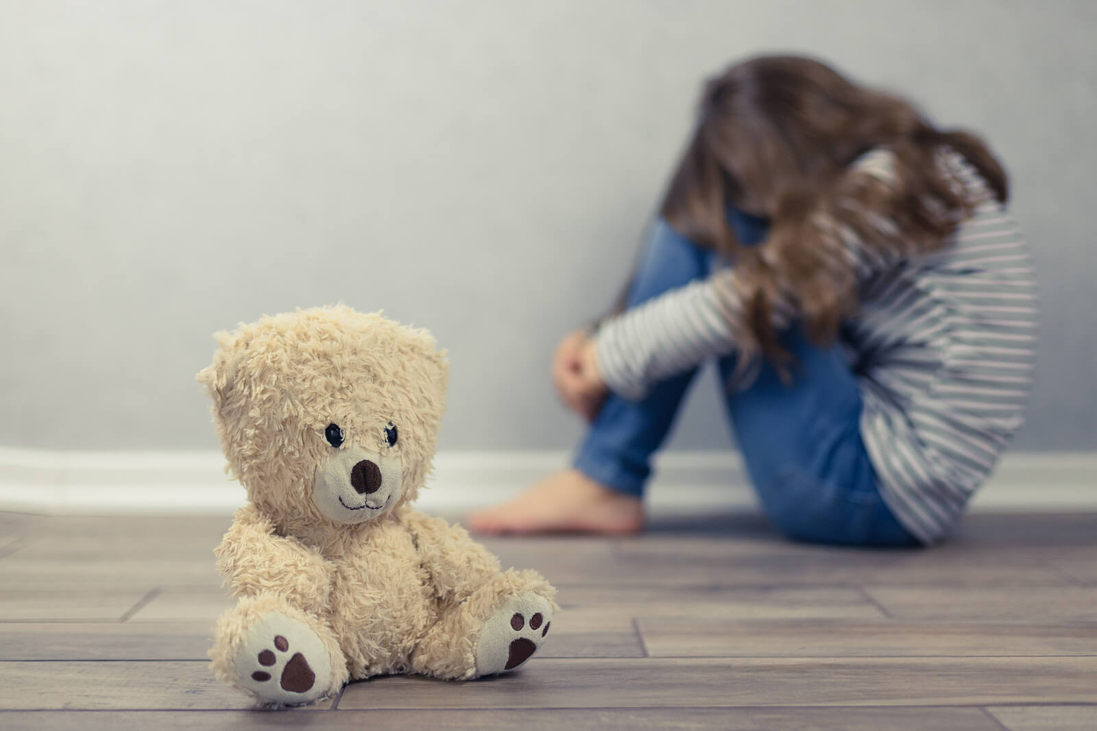 Ragazza molto triste con un orsacchiotto mentre pensa al suicidio.