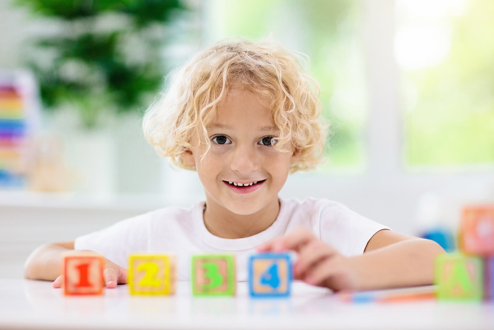 Niño con unos cubos de madera con números.