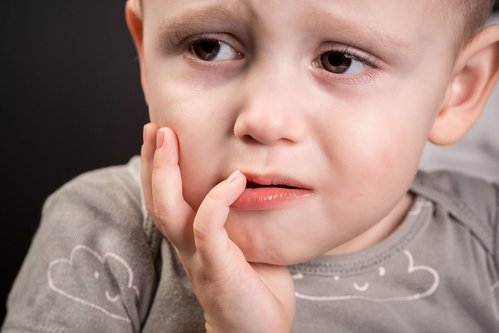 Niño con dolor en la boca y un diente negro.