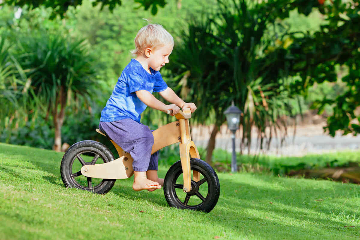 Un niño juega con una bicicleta de equilibrio. 