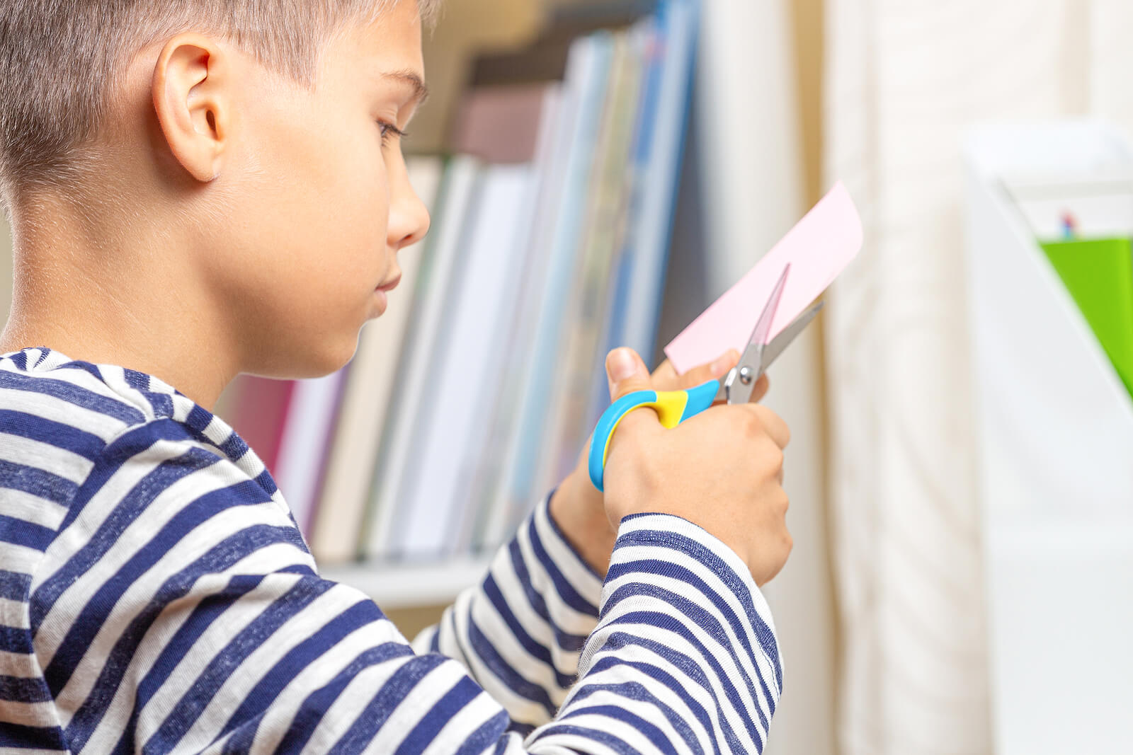 Un enfant qui découpe du papier.