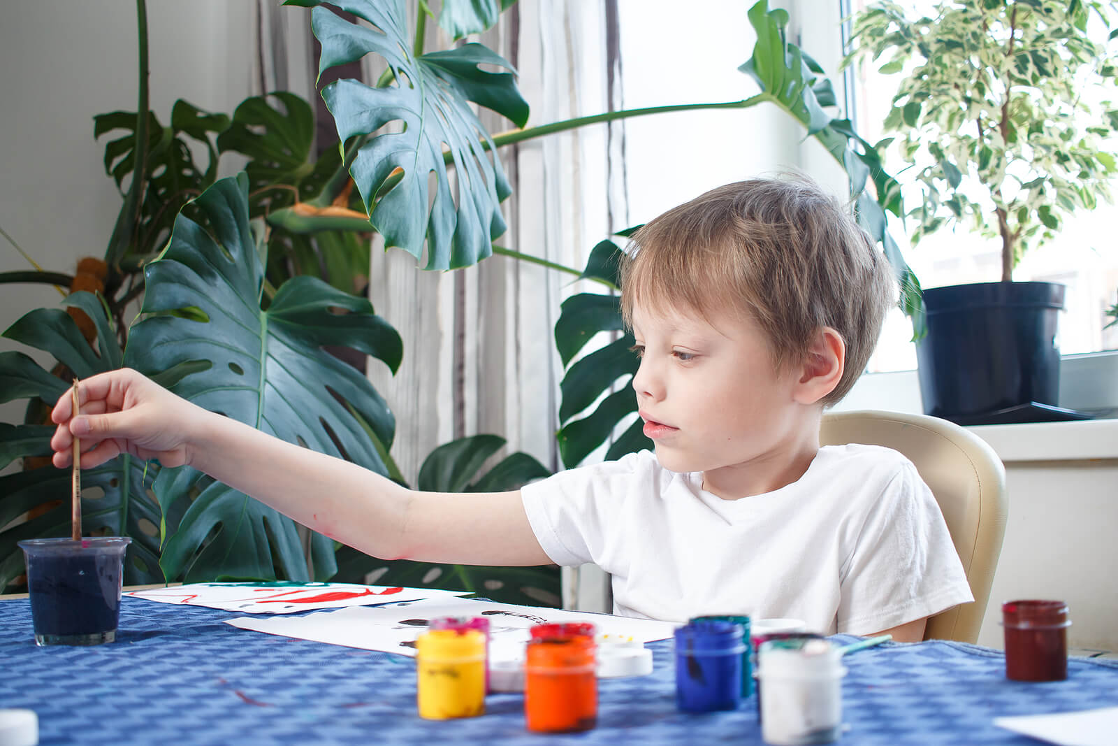 Niño pintando y dibujando con témperas.