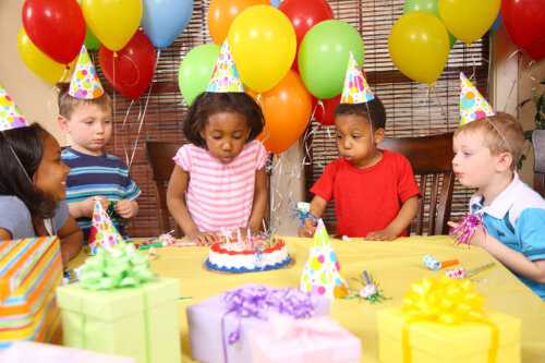 Niños en su fiesta de cumpleaños soplando las velas.