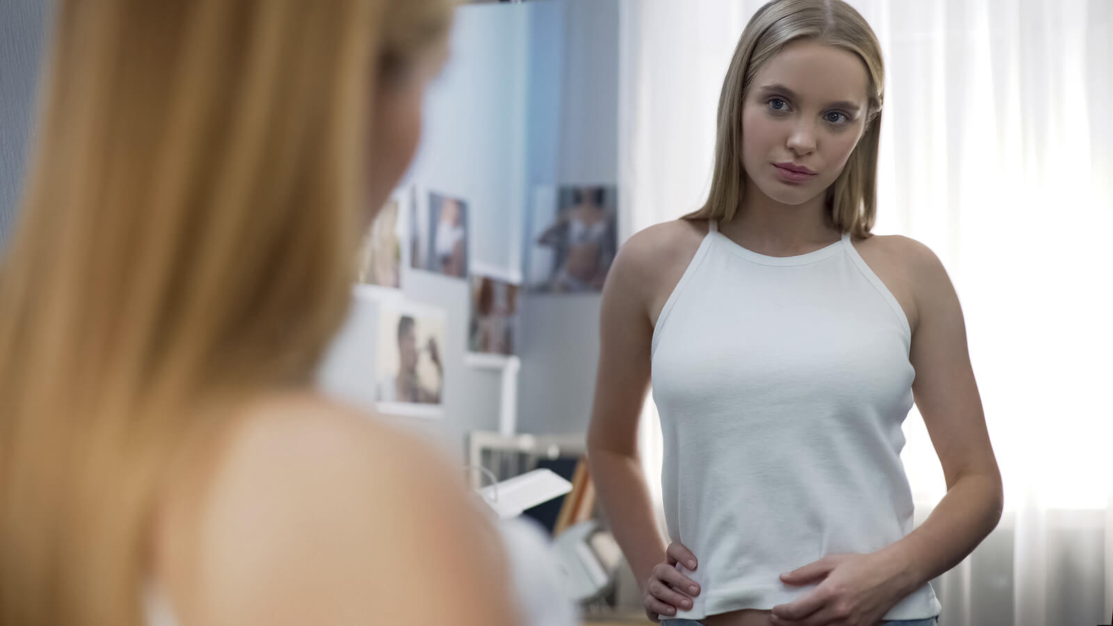 Chica adolescente mirándose al espejo.