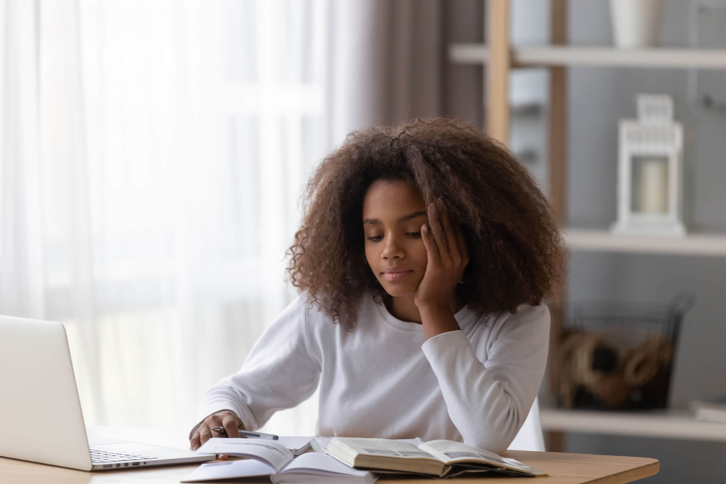 Chica muy distraída estudiando.