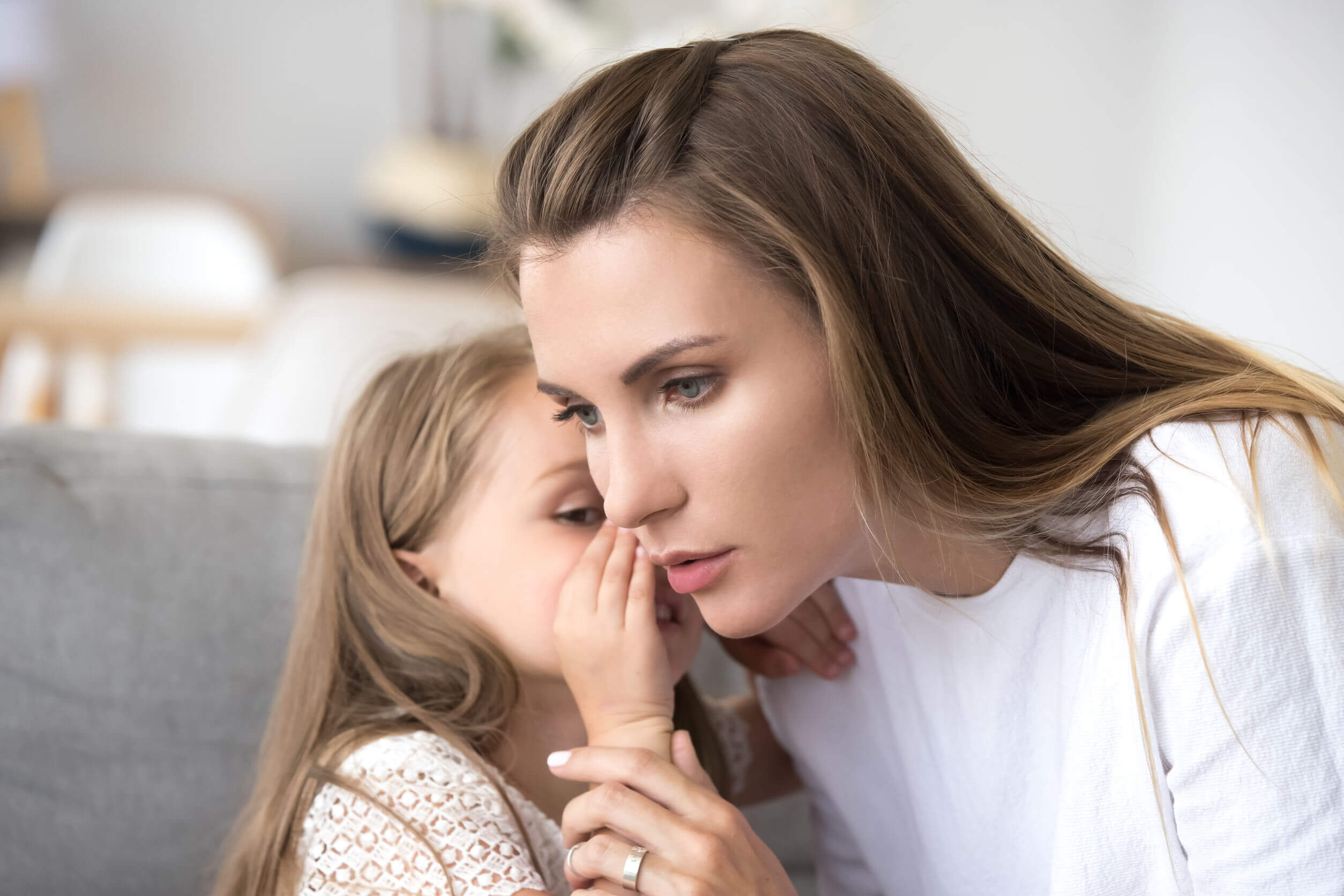 Une jeune fille qui parle en secret à sa maman.