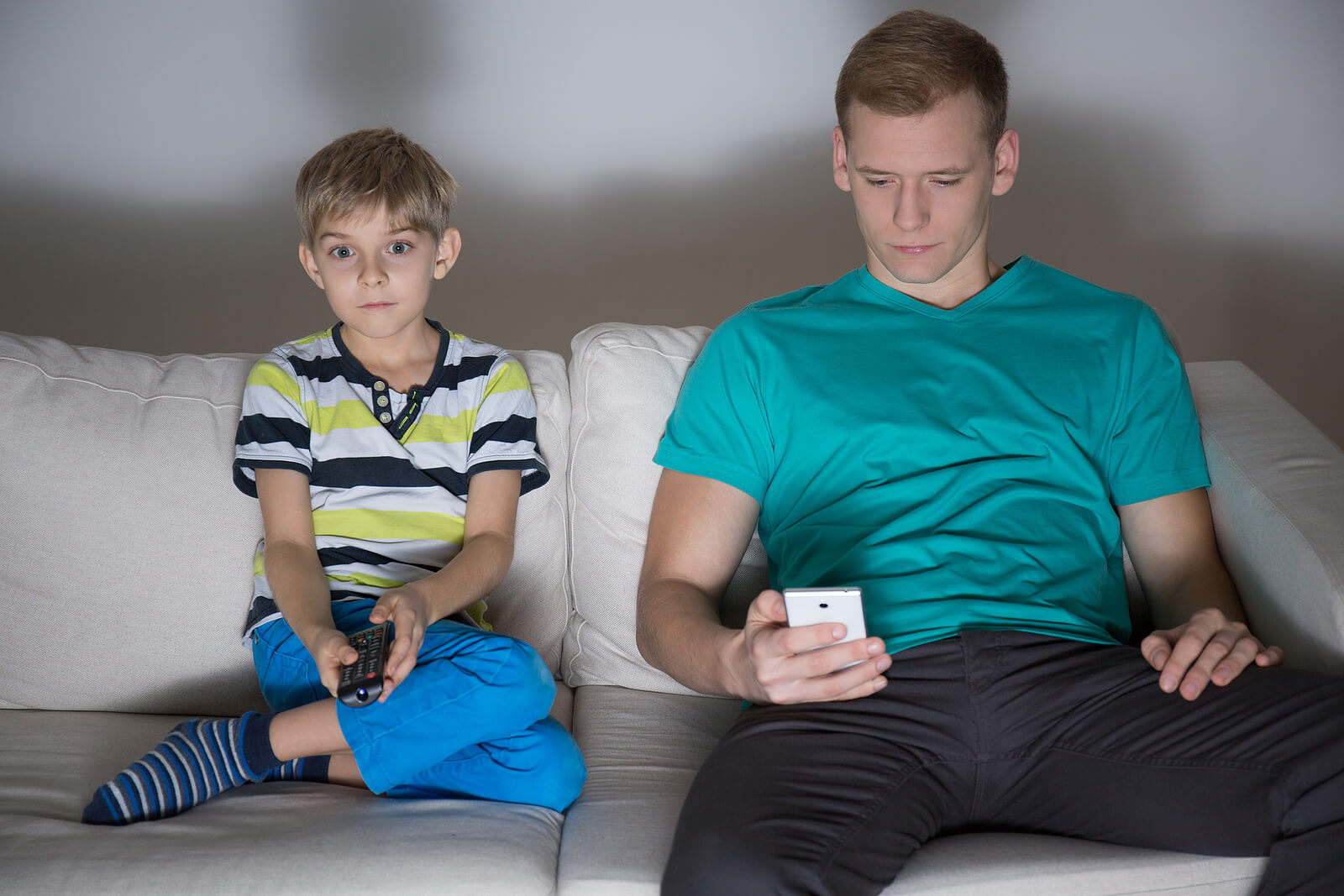 Un jeune garçon et son papa devant les écrans.