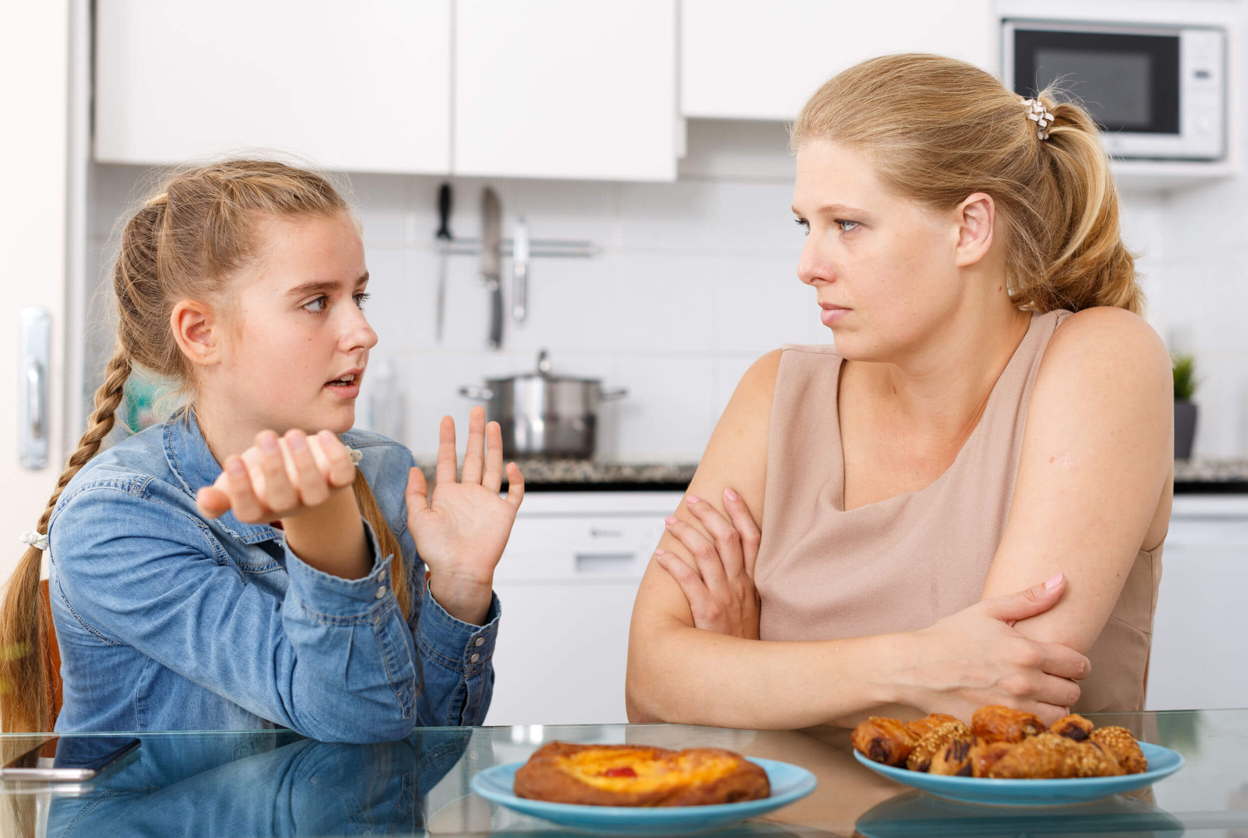 Madre e hija hablando durante el desayuno.