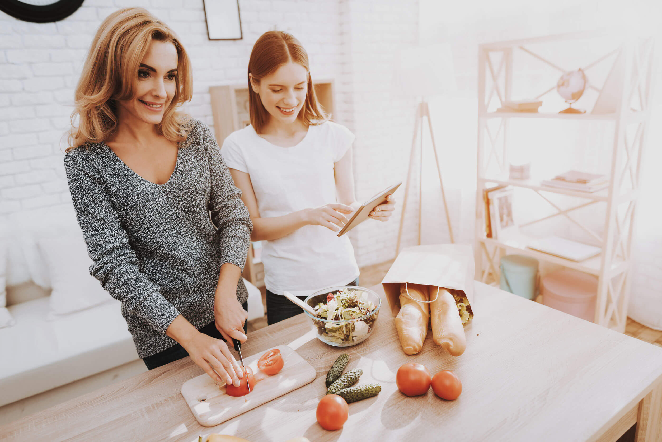 Madre e hija cocinando juntas porque es muy importante comer saludable durante la adolescencia.