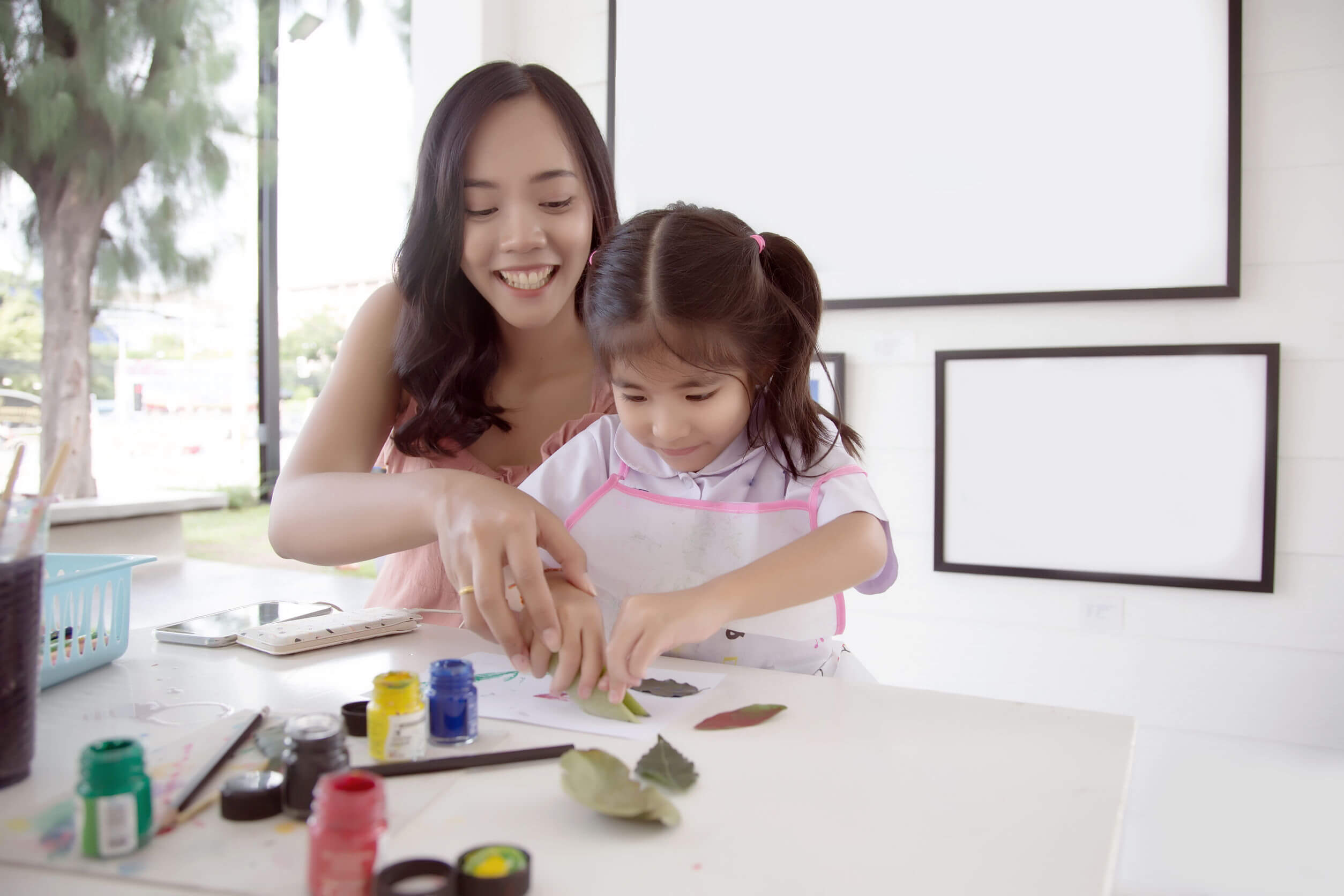 En mor som driver med håndverk med datteren sin.