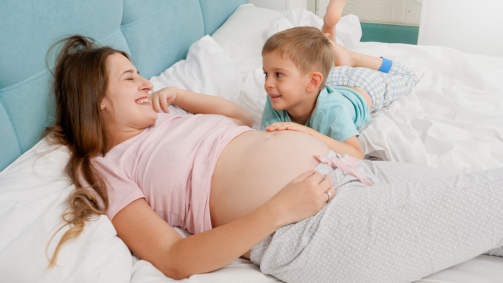 Un enfant qui touche le ventre de sa maman enceinte.
