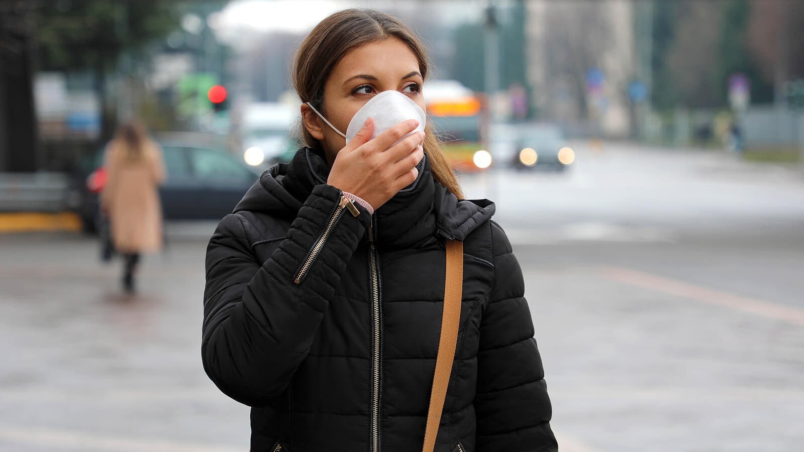 Femme marchant dans la rue avec le masque.