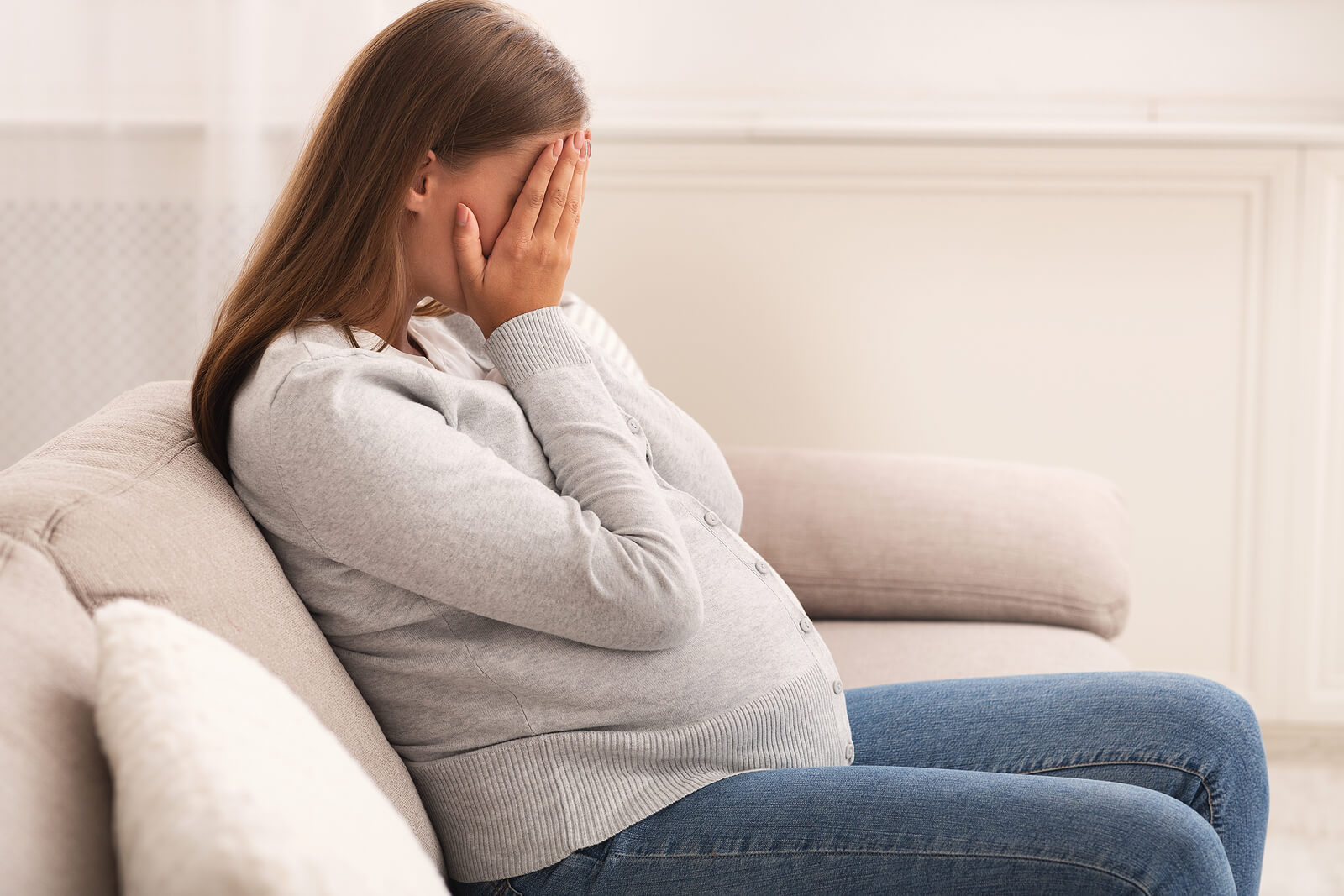 Mujer embarazada llorando porque sufre tocofobia.