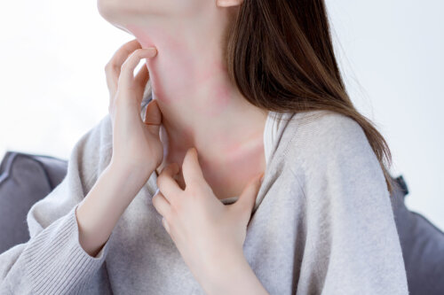 Mujer con piel atópica rascándose el cuello.