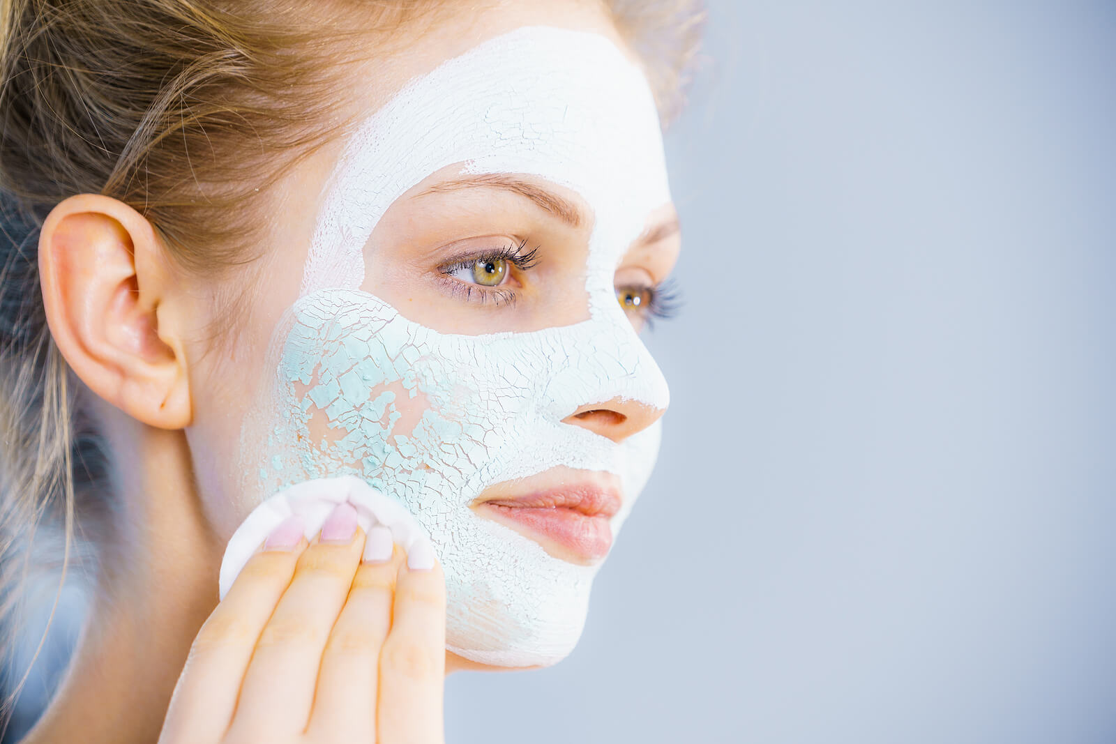 Mujer con la piel grasa aplicando una mascarilla de arcilla.