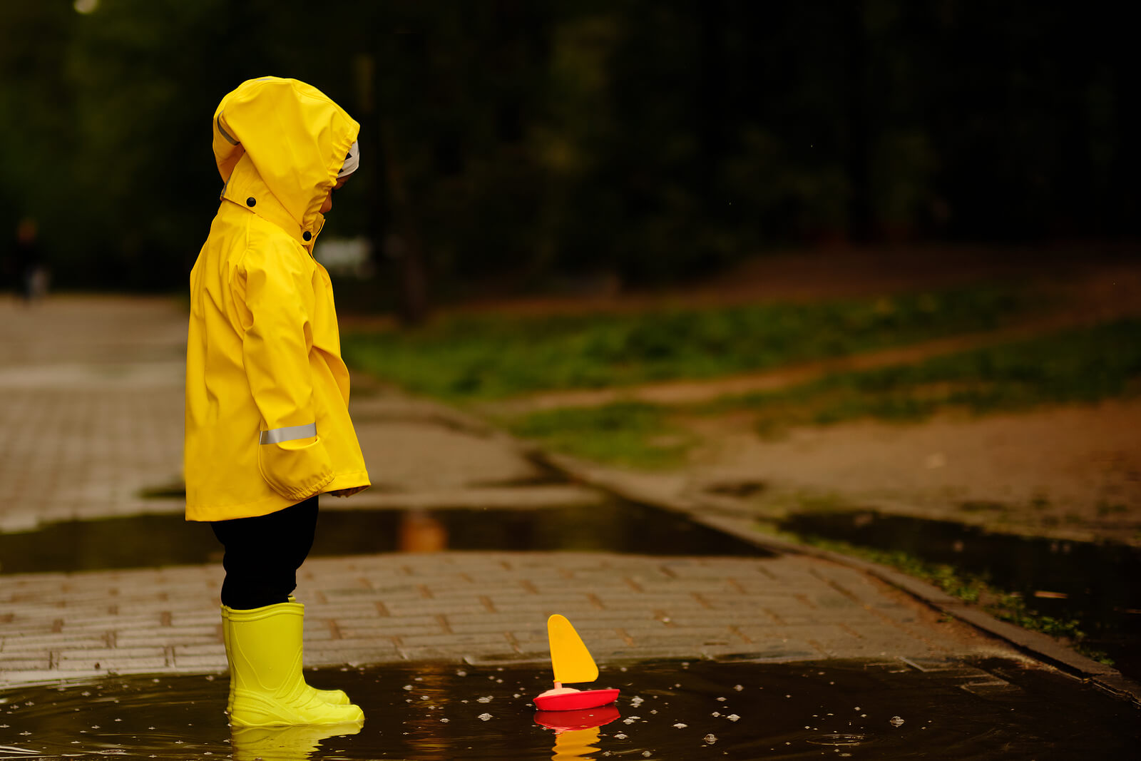 Un enfant sous la pluie avec un ciré jaune.