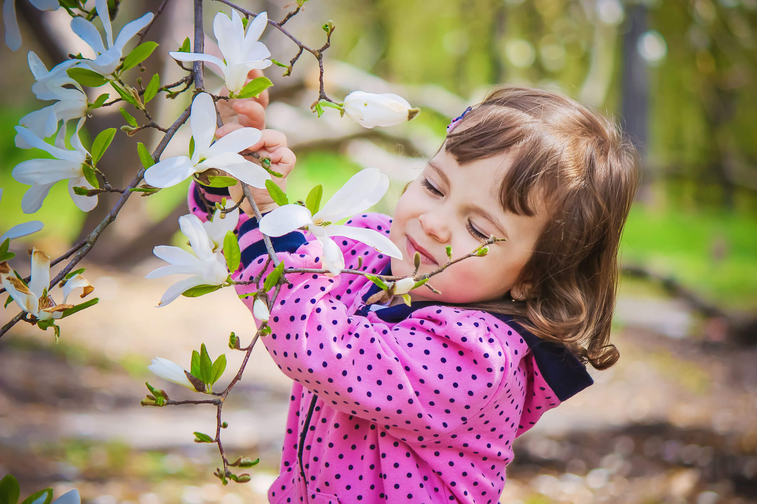Niña oliendo flores para perder su miedo a la abejas.