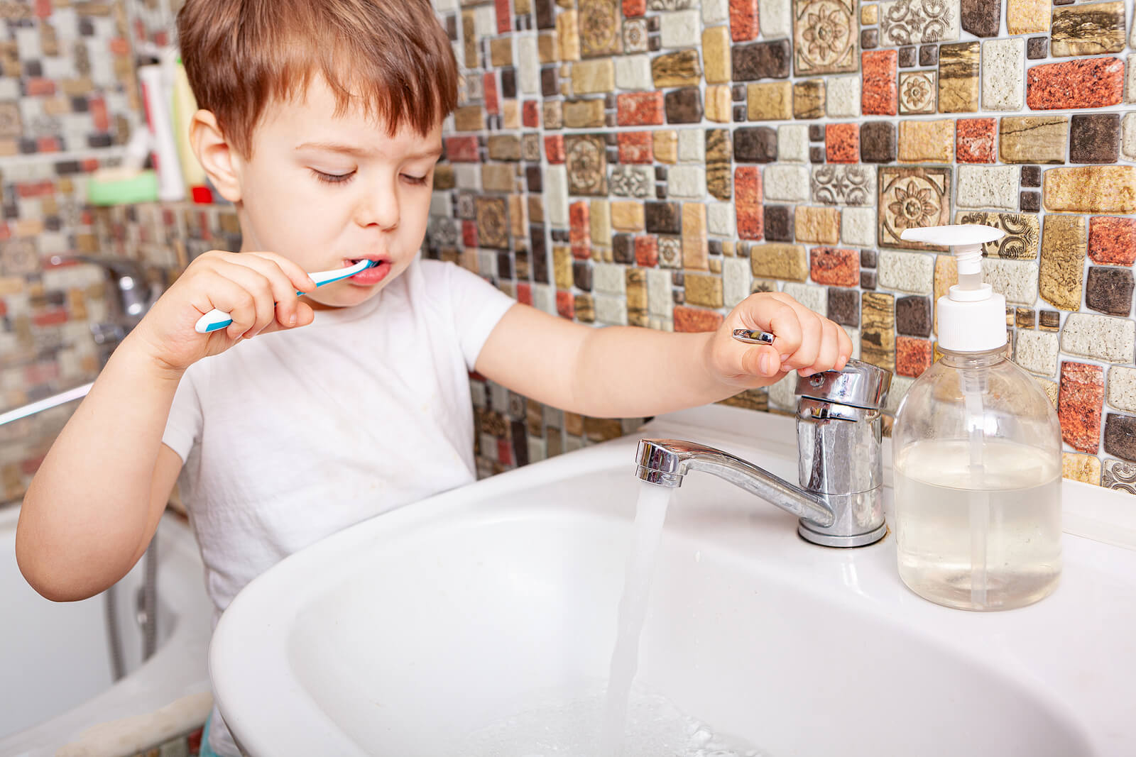 Pojke borstar tänderna för att undvika tandsten.