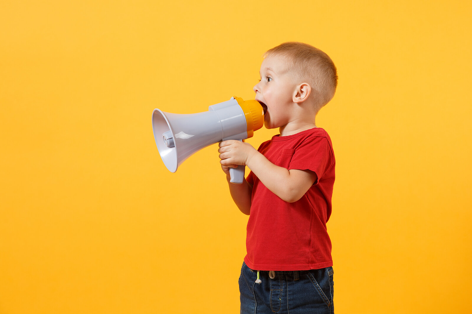 Enfant parlant avec un mégaphone pour le développement du langage entre 1 et 2 ans.