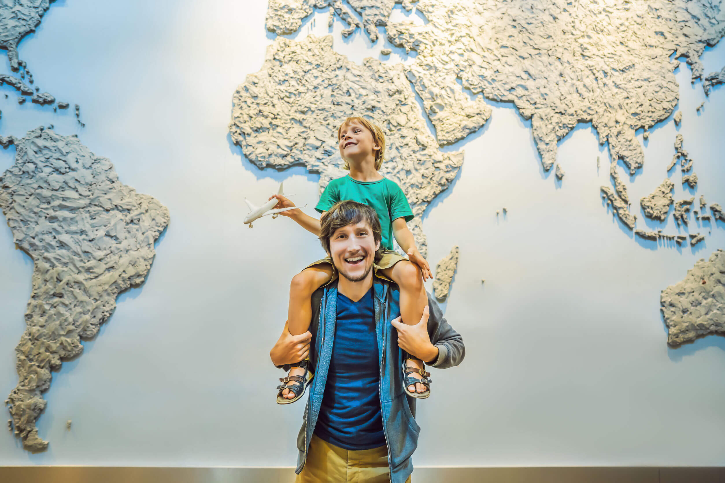 Padre e hijo con un mapamundi detrás.