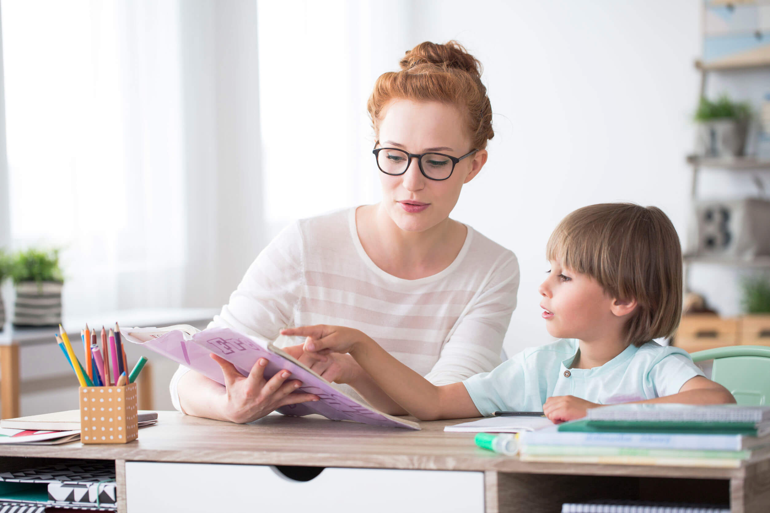 Enseignant avec un élève ayant des besoins spécifiques programmant des adaptations curriculaires.