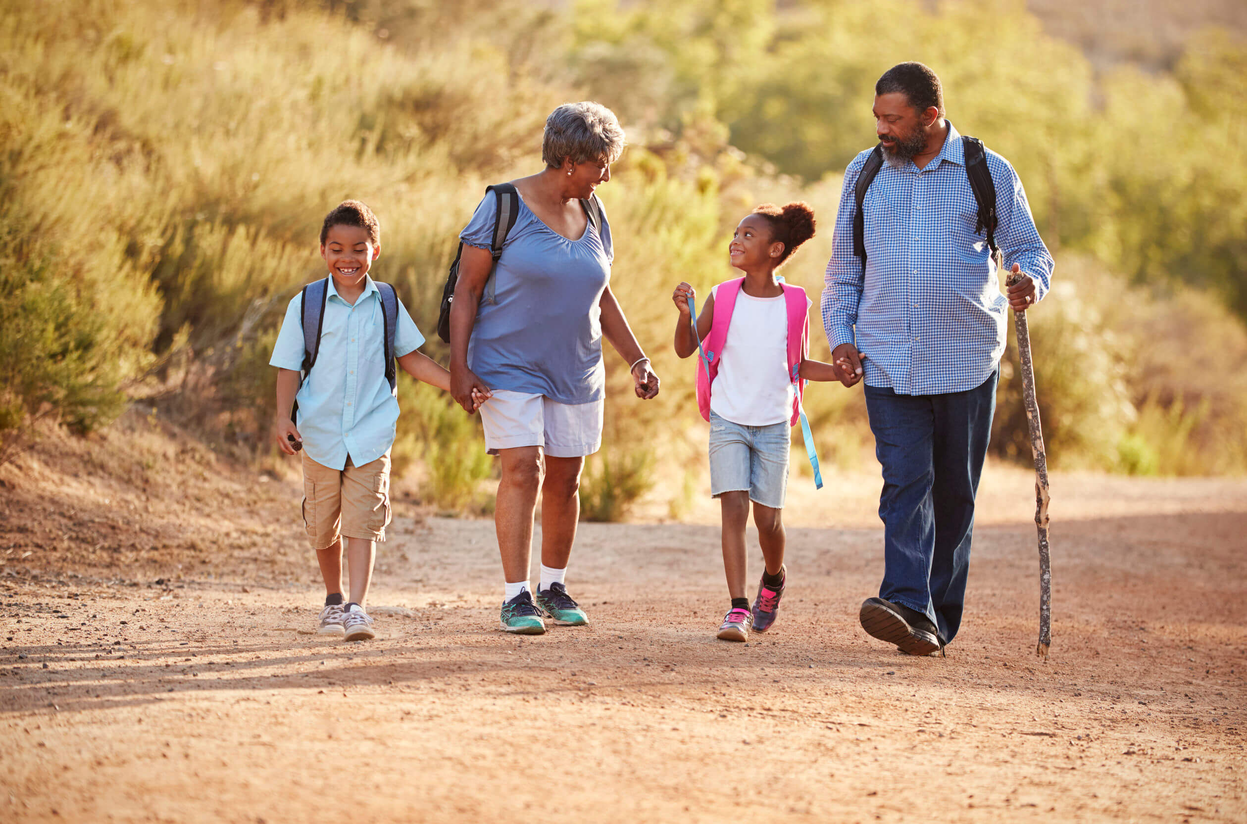 Des grands-parents qui se promènent avec leurs deux petits-enfants;