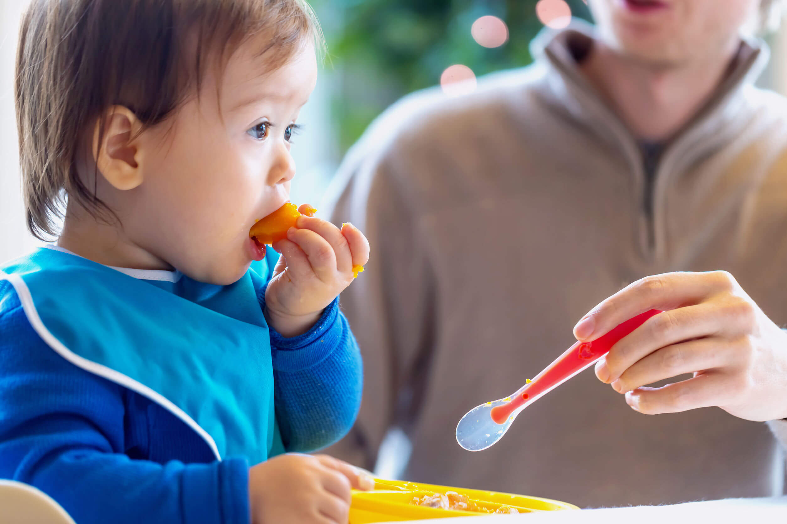 Bambino che mangia frutta mentre impara a masticare.