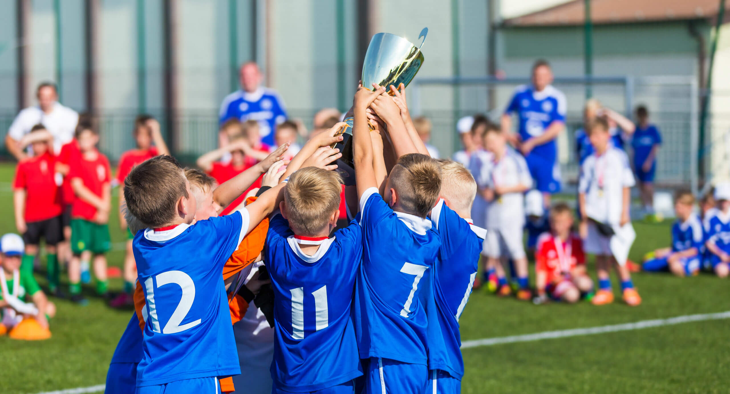 A boys' soccer team holdingu p a trophy.