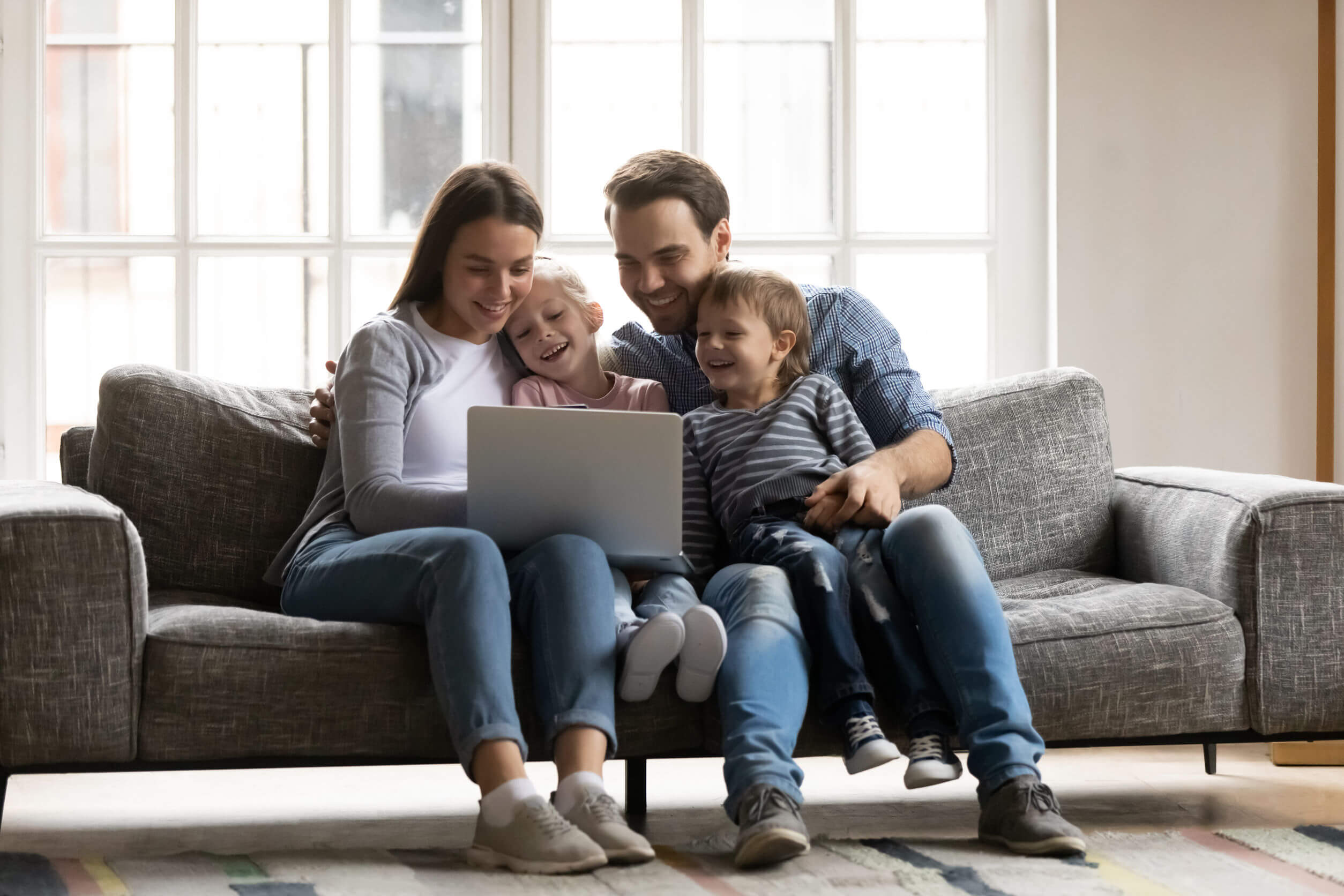 Familia viendo en el ordenador algunos de los mejores canales educativos como parte de los planes gratis online.