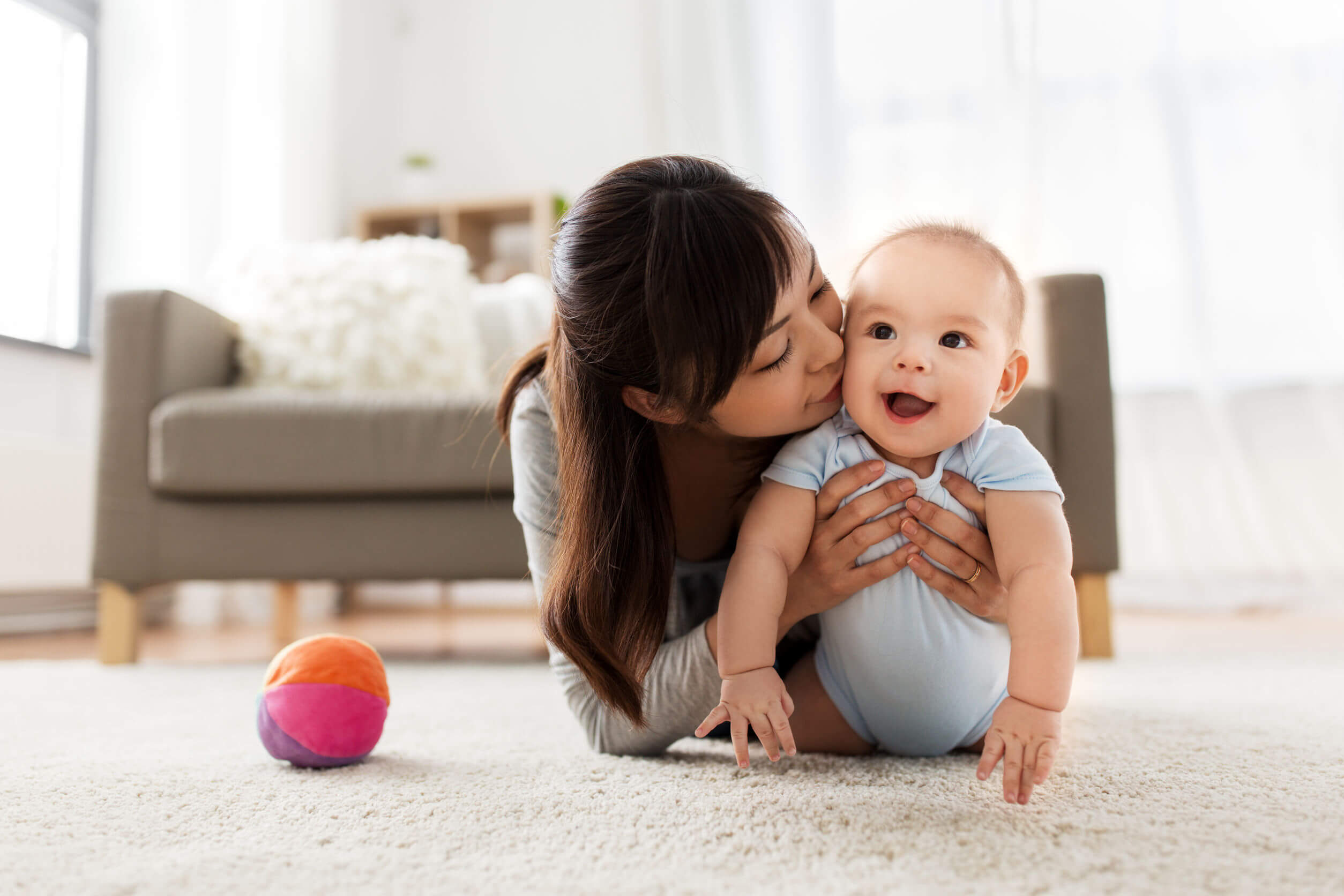 Mère avec son bébé explorant le salon à la maison.