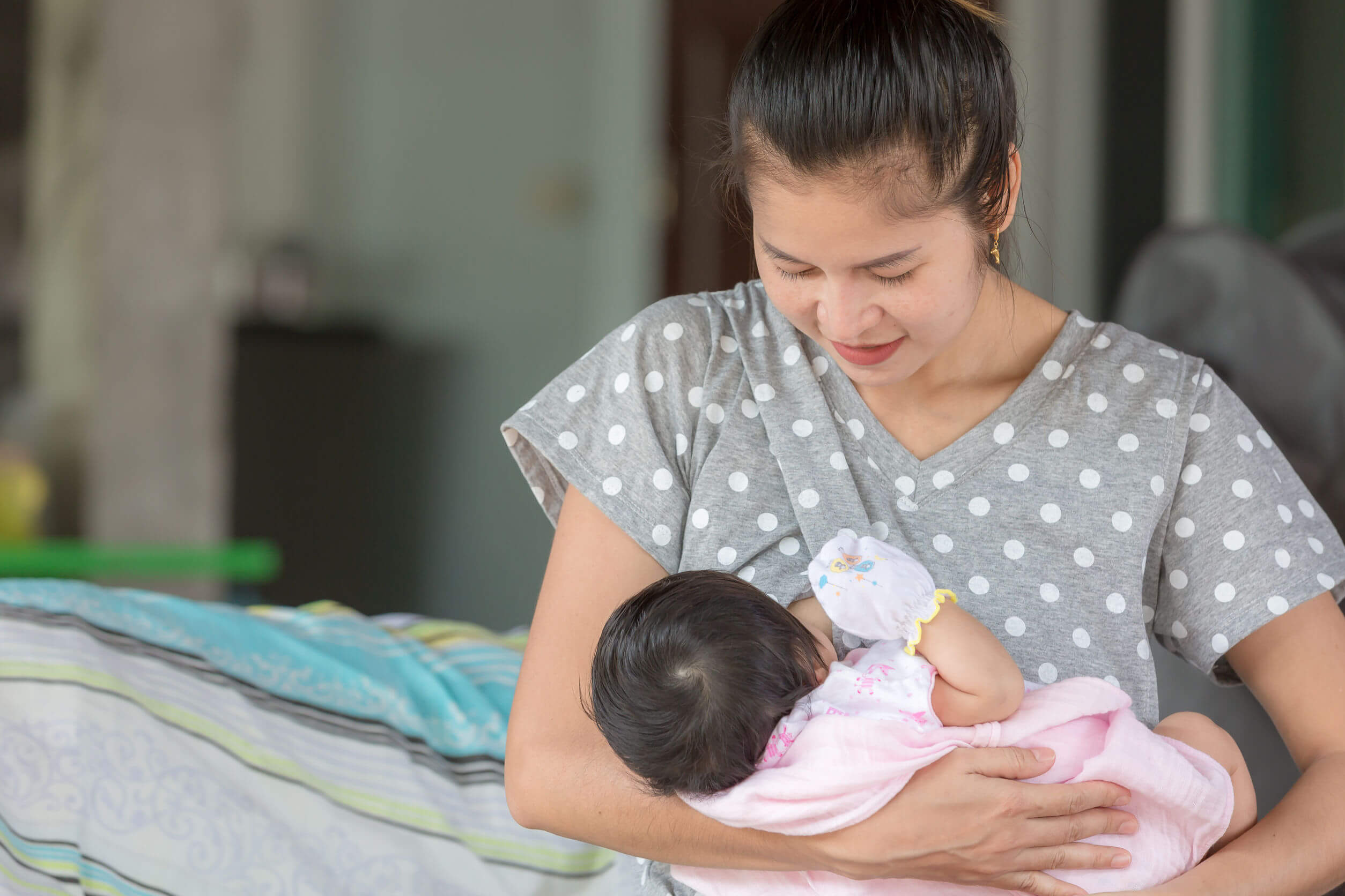 Mamma che allatta il suo bambino con i paracapezzoli.