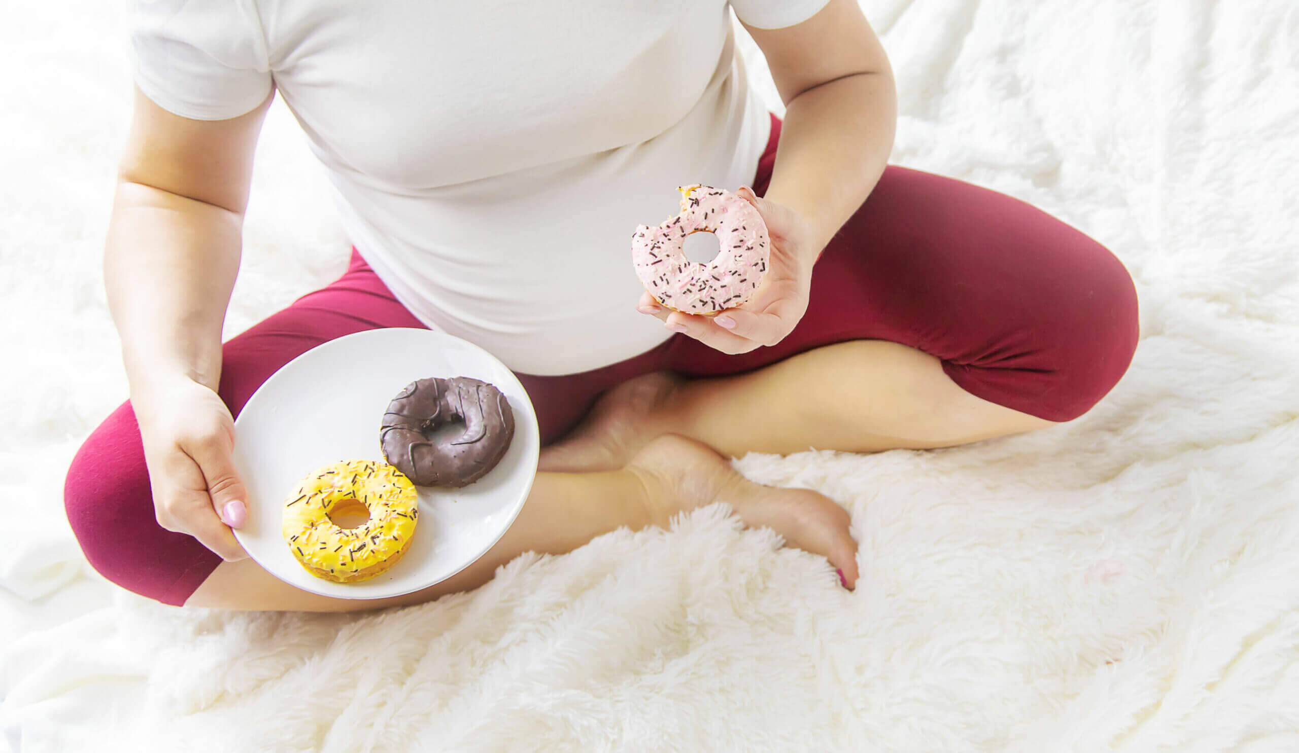Mujer embarazada comiendo rosquillas.