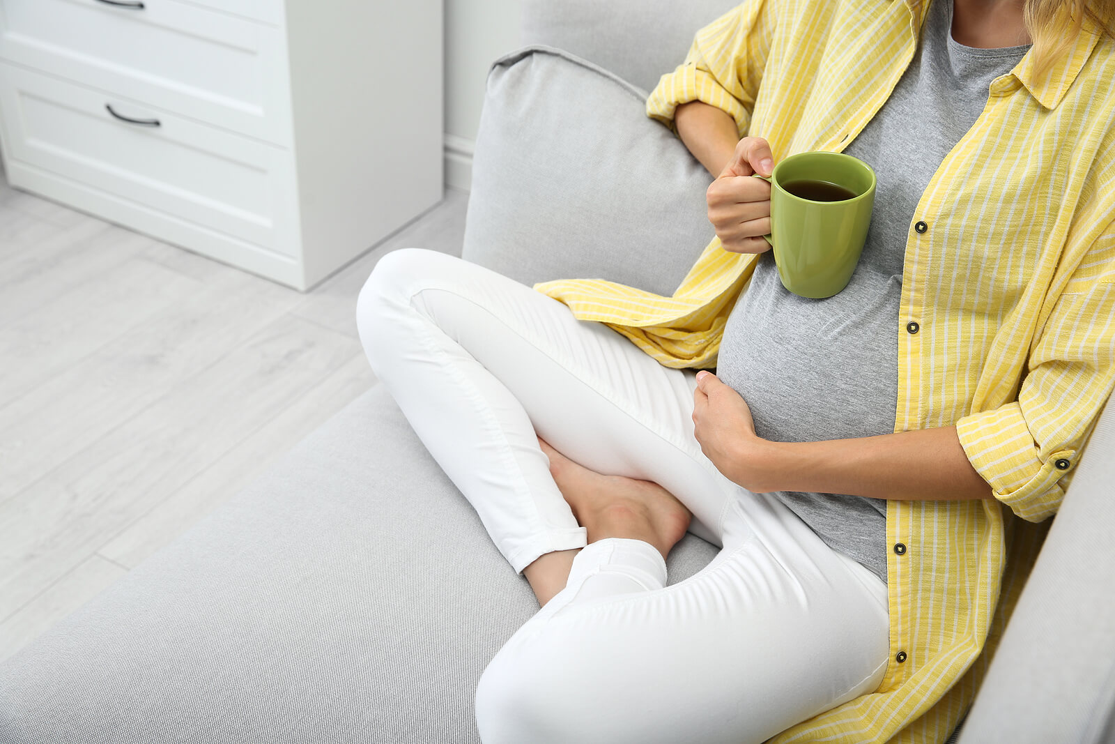 Een zwangere vrouw drinkt een infusie
