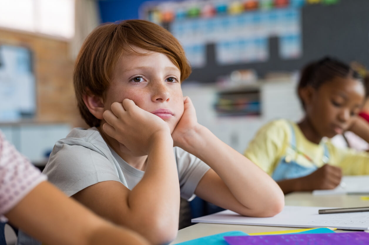 Niño que se aburre en la escuela.