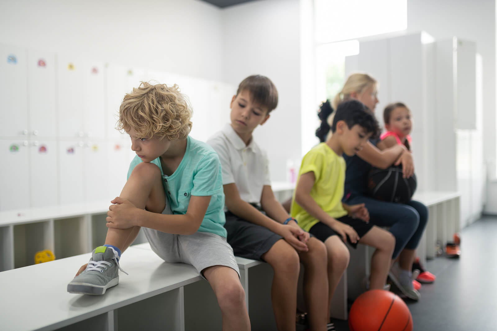 Niño en el vestuario sufriendo acoso en el deporte.
