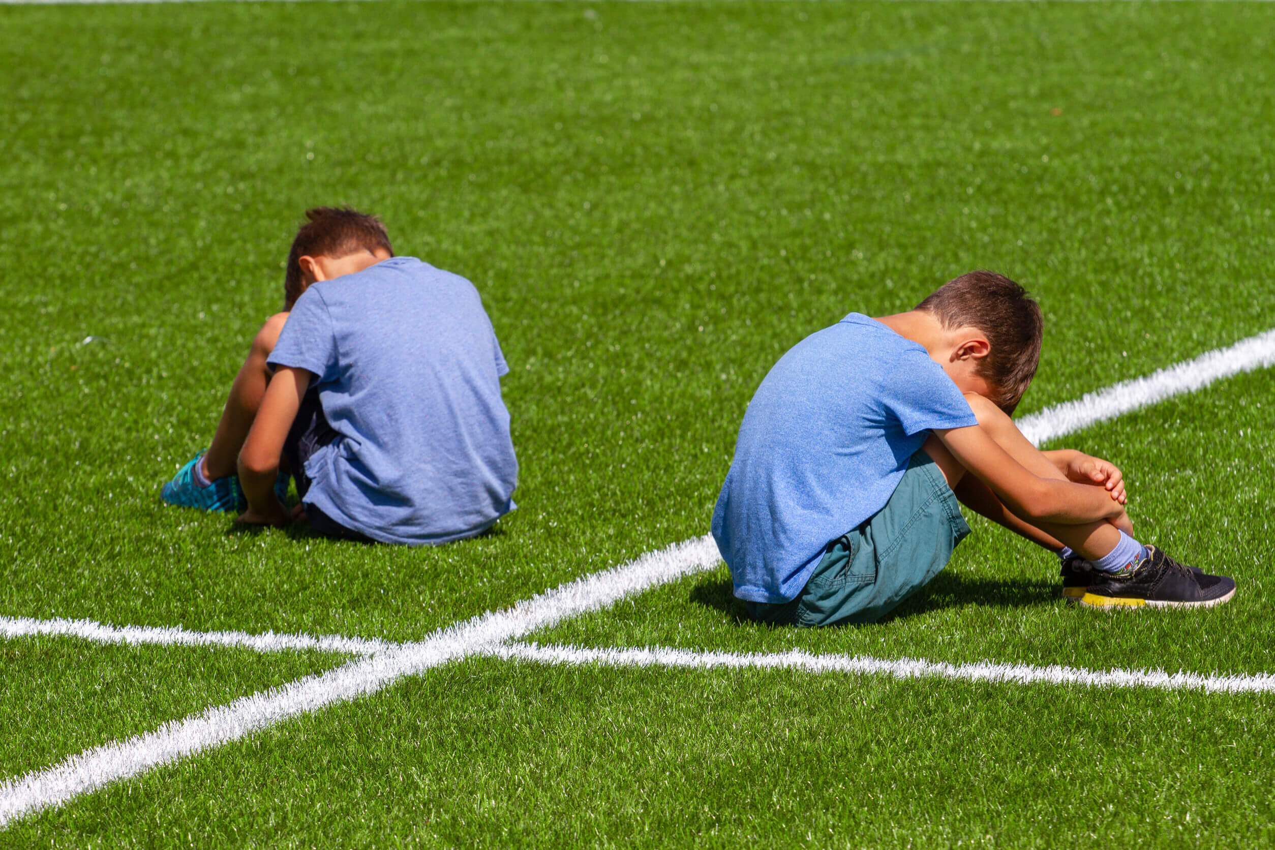 Niños sufriendo acoso en el campo de fútbol.