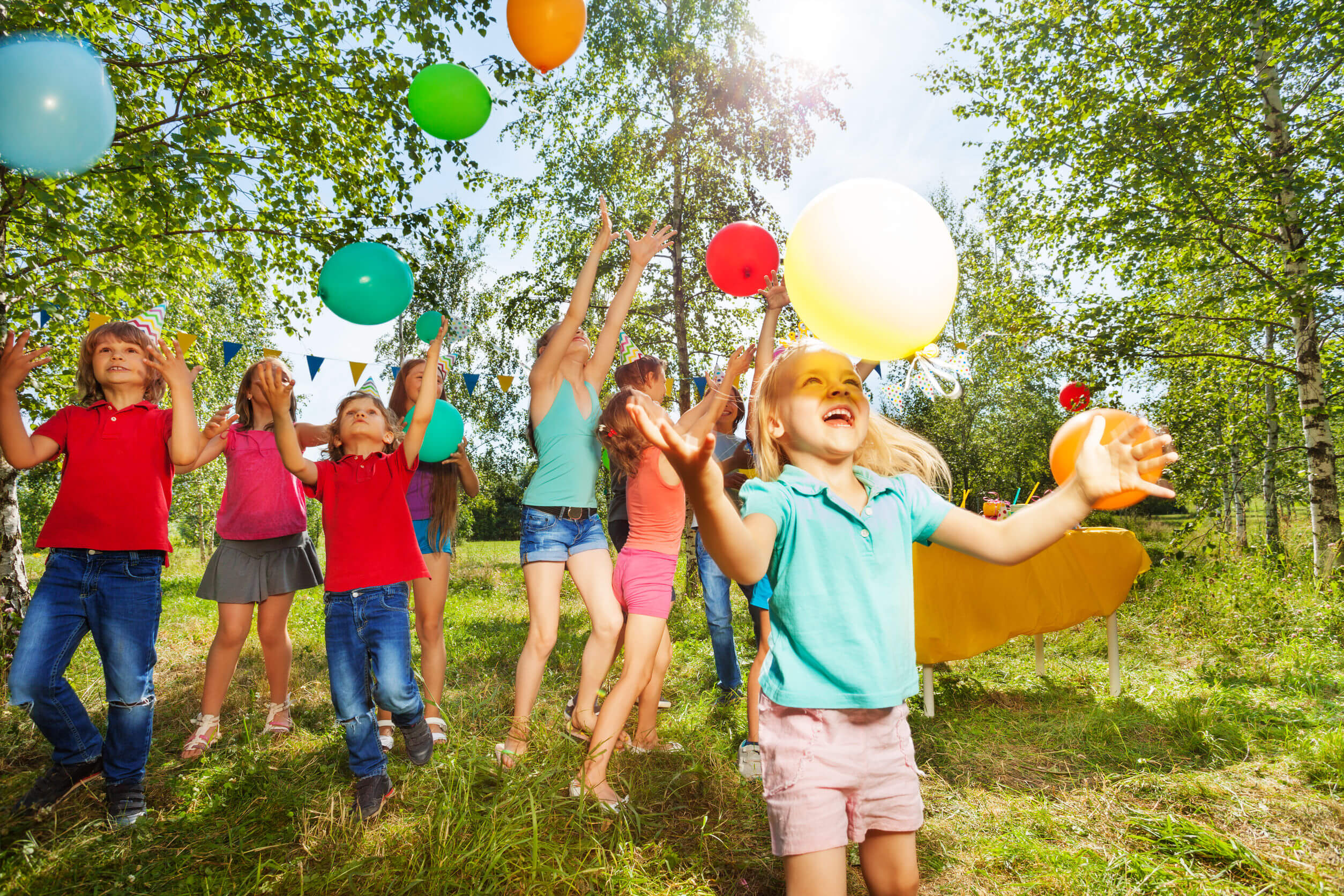 Children playing with balloons outside.