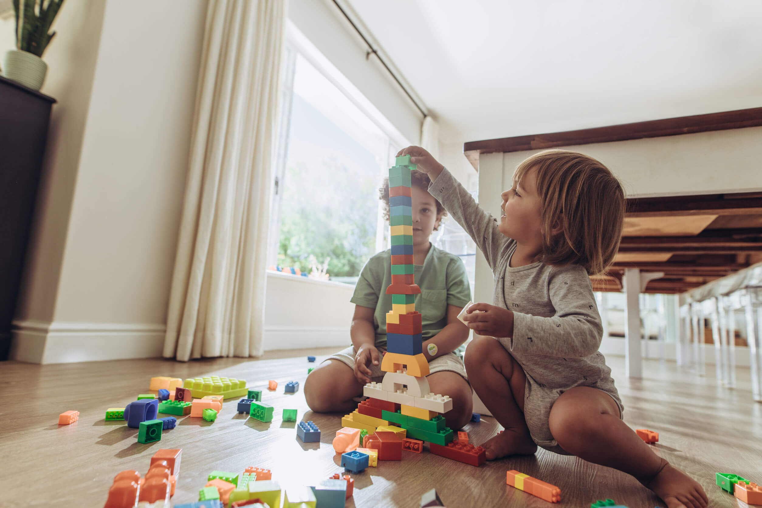 Niños jugando con piezas LEGO para que sus padres conozcan su bondad de ajuste.