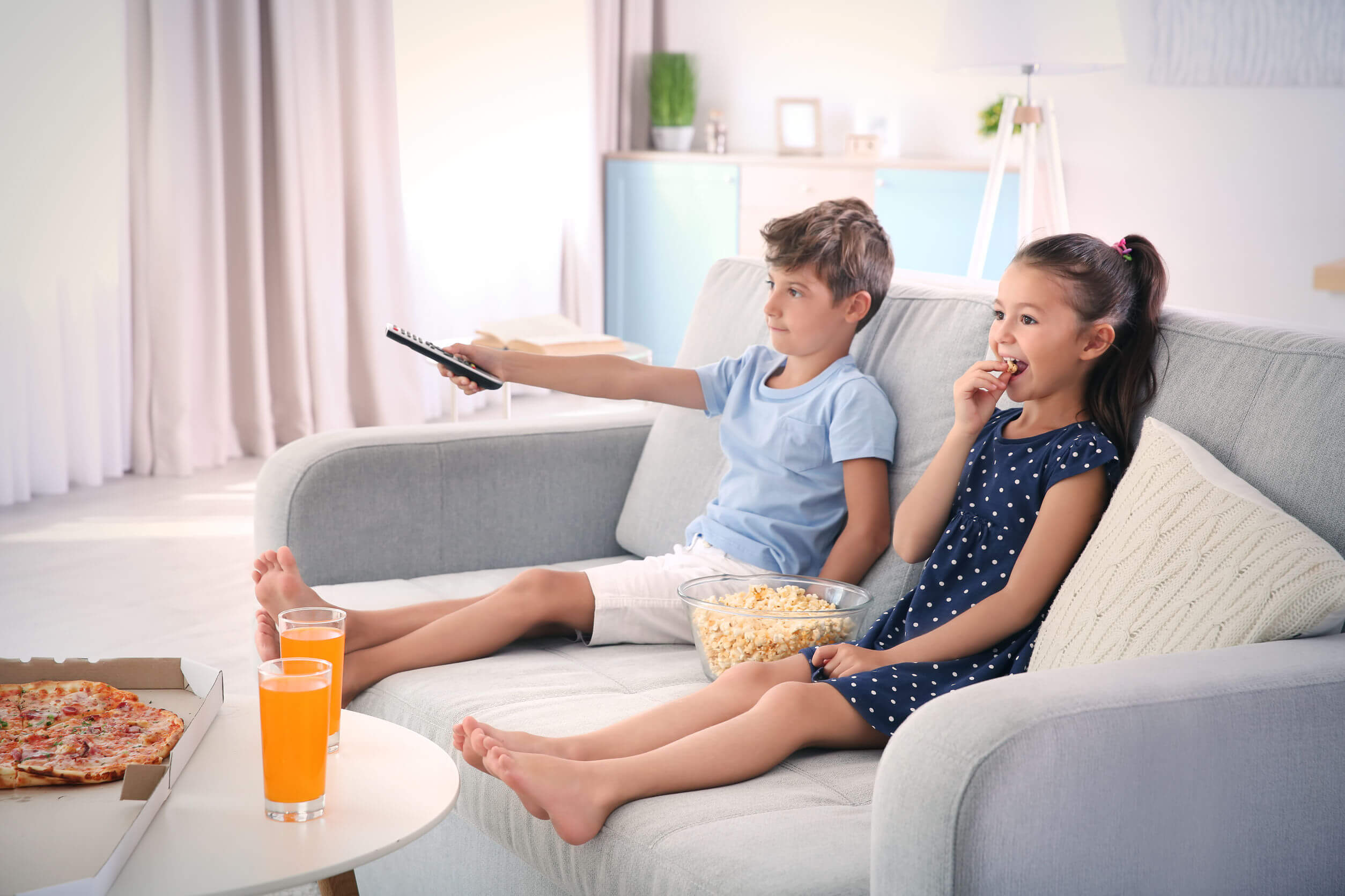 Niños viendo la televisión sin darse cuenta de la influencia de la publicidad en la alimentación infantil.