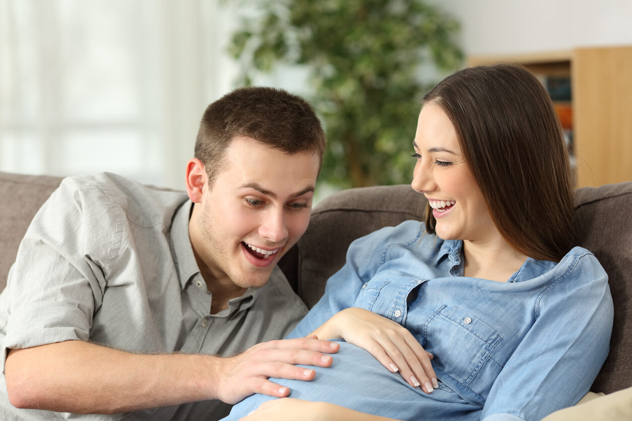Heureux futurs parents pensant à des noms inhabituels pour leur bébé.