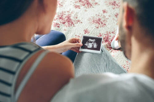 Futuros padres mirando una ecografía y pensando en nombres de niño que empiecen por la letra A.