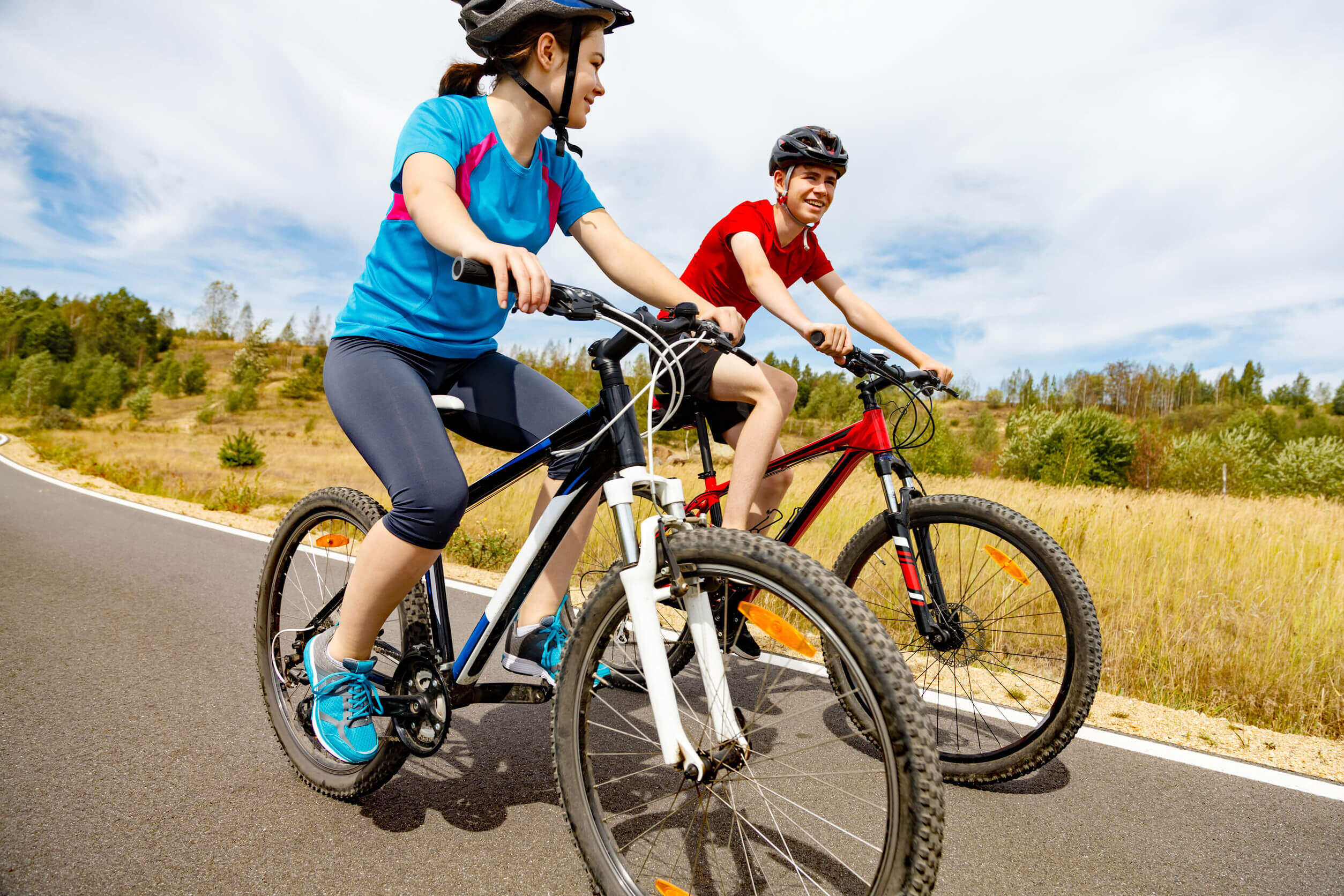 Adolescentes montando en bicicleta porque conocen los beneficios del deporte en la adolescencia.