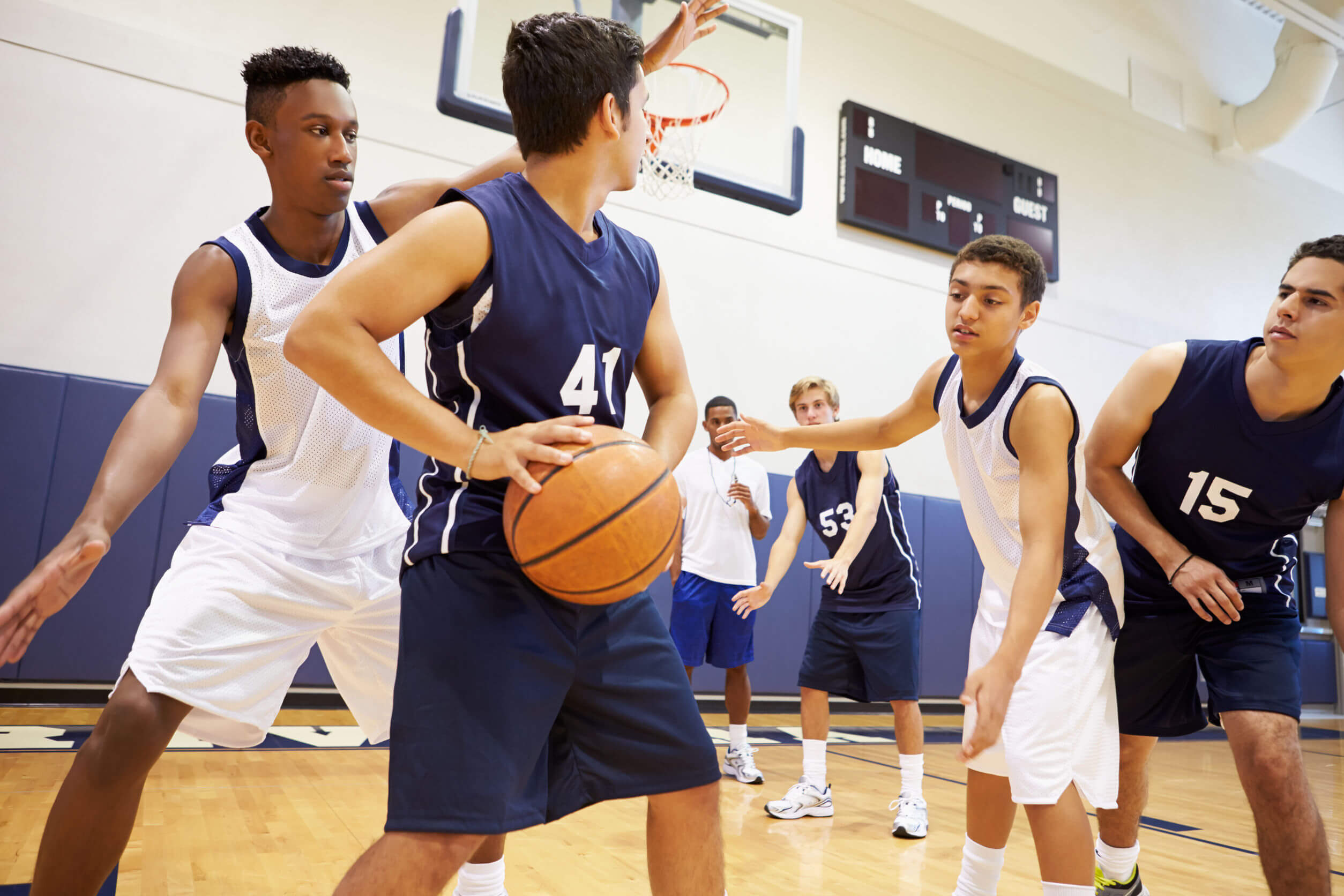 Adolescentes jugando en un equipo de baloncesto.