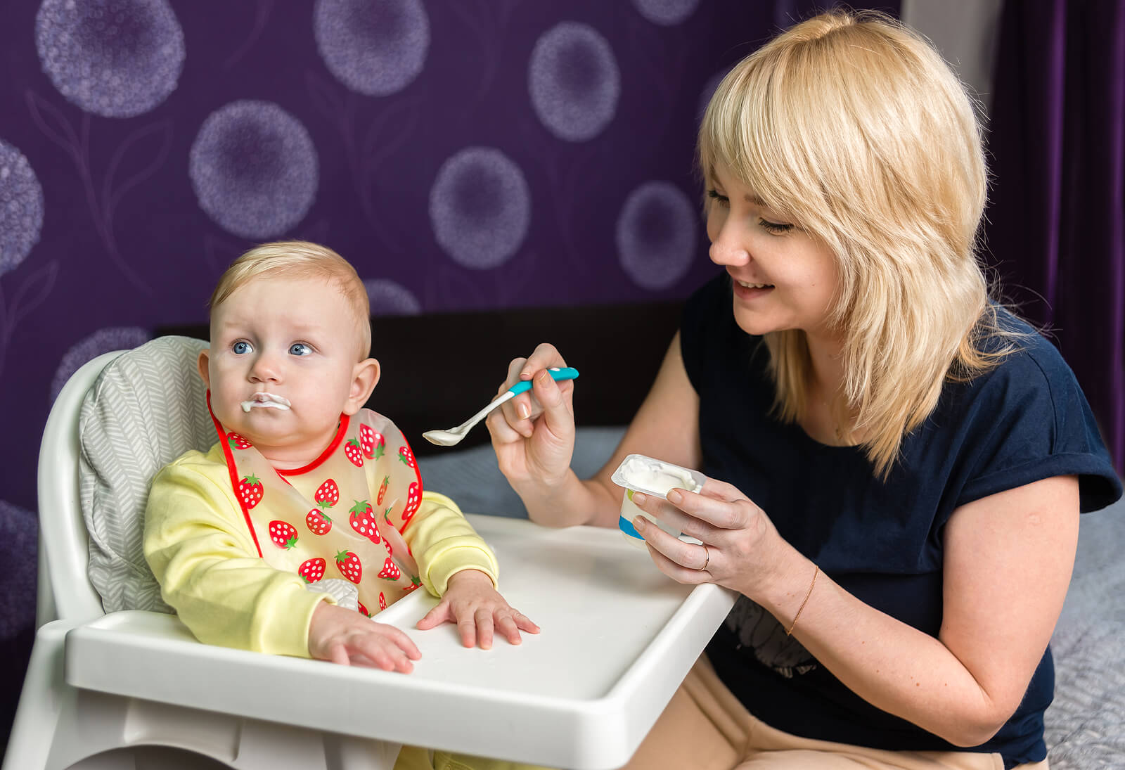 Bébé mange du yaourt pour renforcer le système immunitaire.